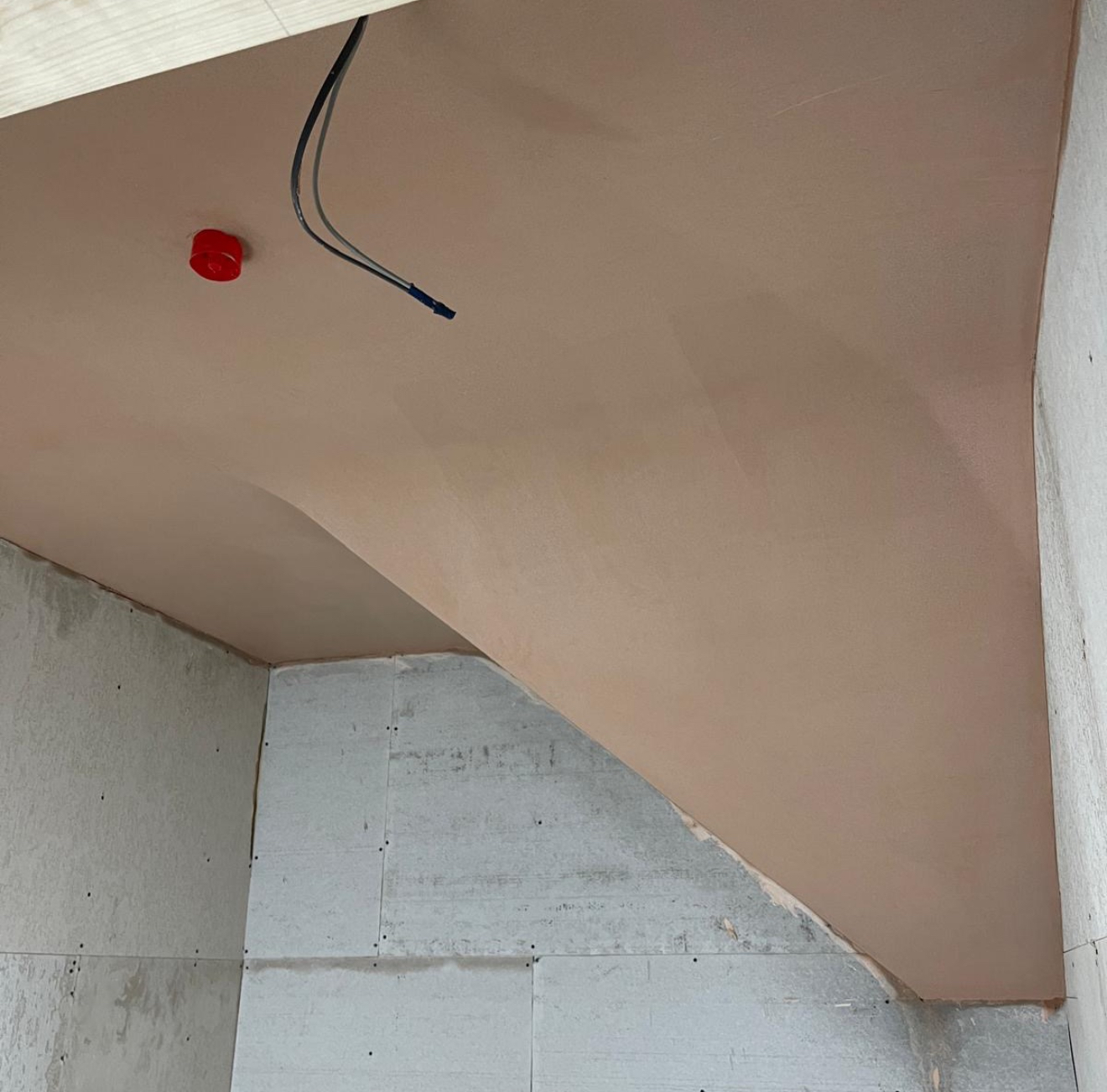 Plastered sloping ceiling under the stairs