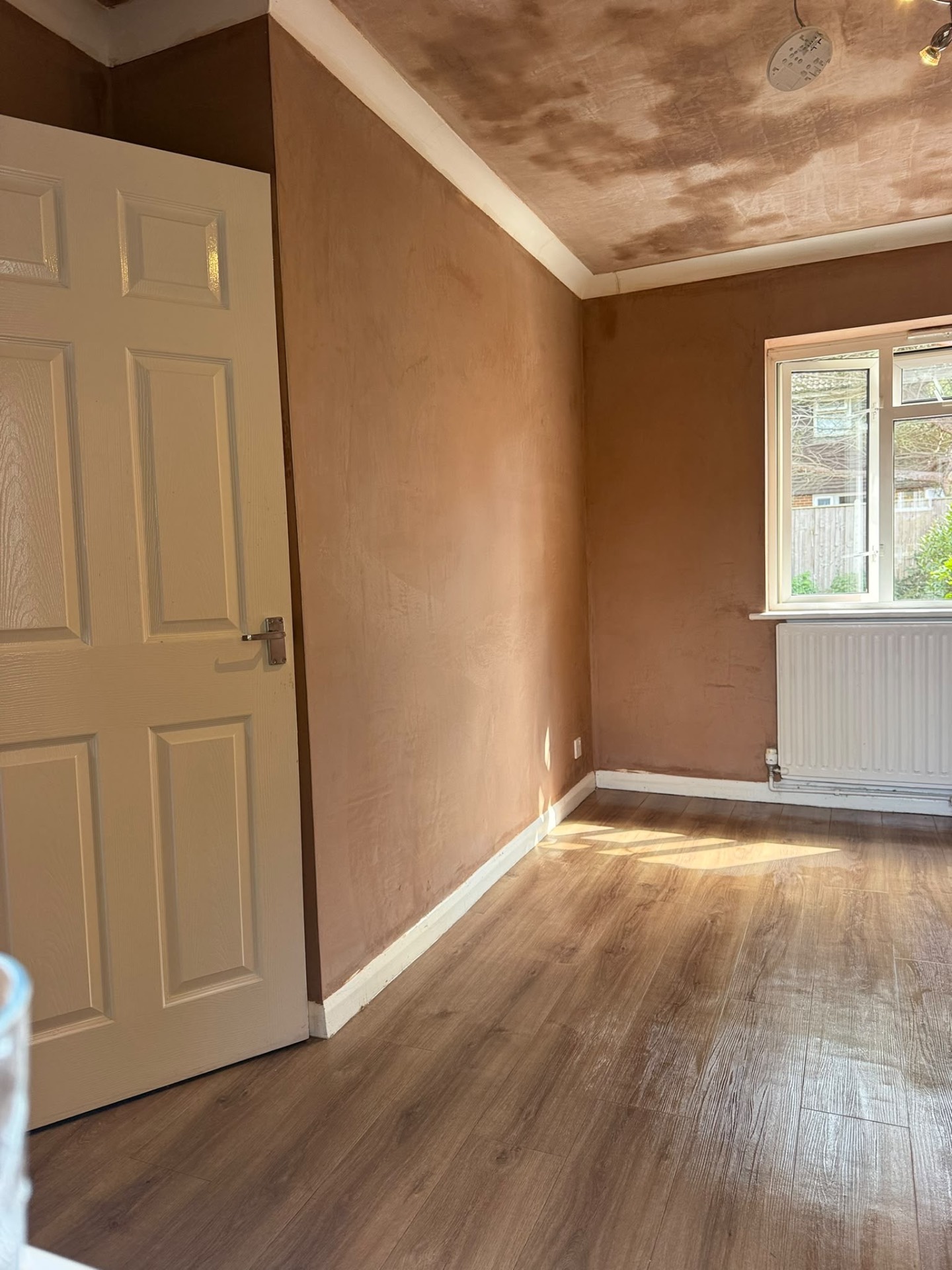 Plastered bedroom walls with a white door
